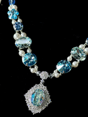 Close-up detail shot of luxury handmade dog necklace, multi-cut blue crystals, pearl beads and sparkling halo aquamarine pendant