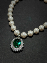Close-up shot of luxury pet pearl necklace, oval emerald center stone with halo crystals, premium dog fashion accessory detail shot