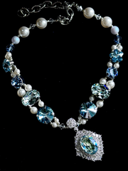 Top-down view of ocean blue crystal pearl dog choker, mixed shape sparkling gems, statement aquamarine pendant, fancy pet party jewelry