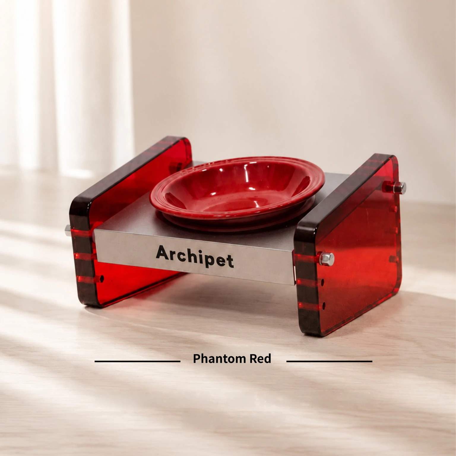 Archipet Phantom Red transparent acrylic elevated pet bowl holder, deep red ceramic cat bowl, designer pet feeding station shot in soft natural light
