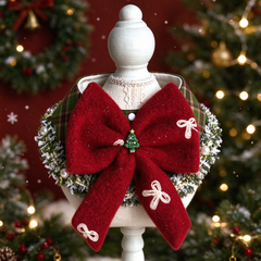 Christmas plaid pet bow collar, fluffy red bow with mini christmas tree charm, pine and pearl trim on mannequin, festive xmas decor background