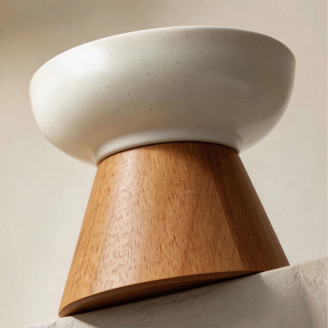Single elevated ceramic cat water bowl with solid wood tapered base, filled with fresh water