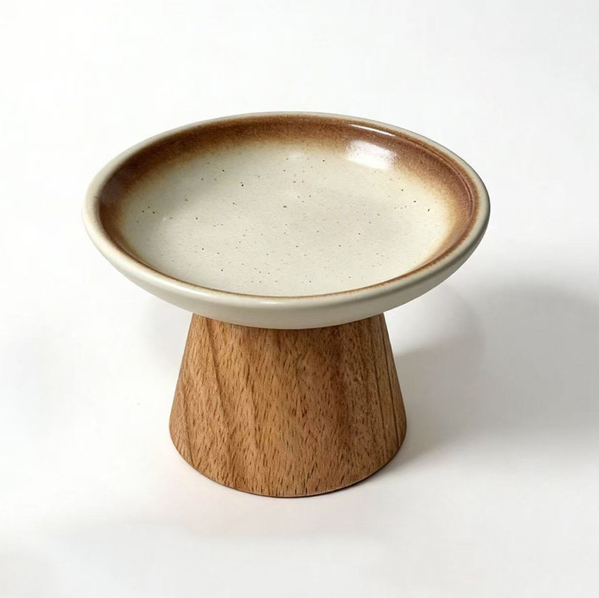 Raised pet food ceramic bowl with solid wood stand, top side view white background